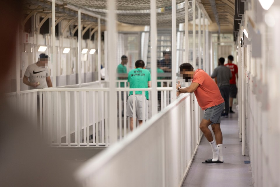 a man in a nike shirt is standing in a hallway