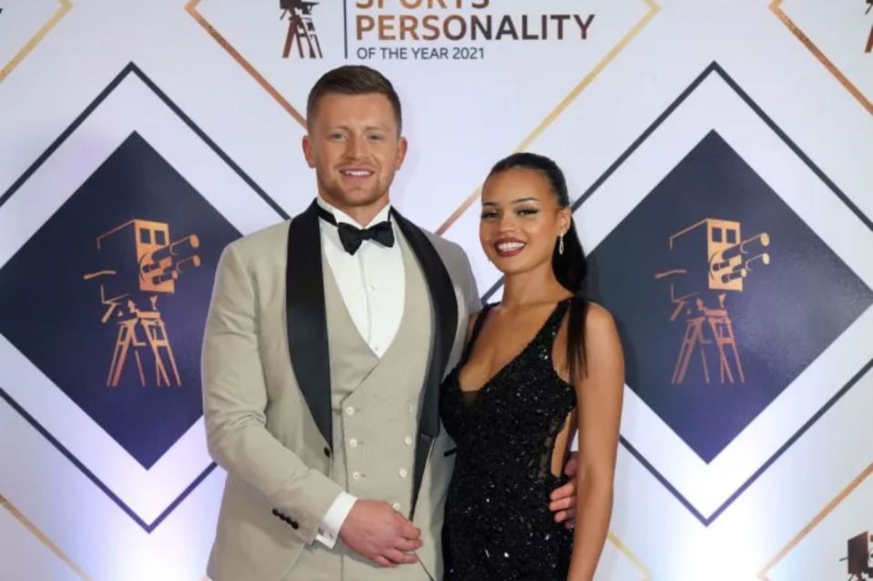 a man and woman pose in front of a wall that says sports personality of the year 2021