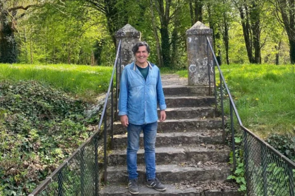 a man in a blue shirt is standing on a set of stairs