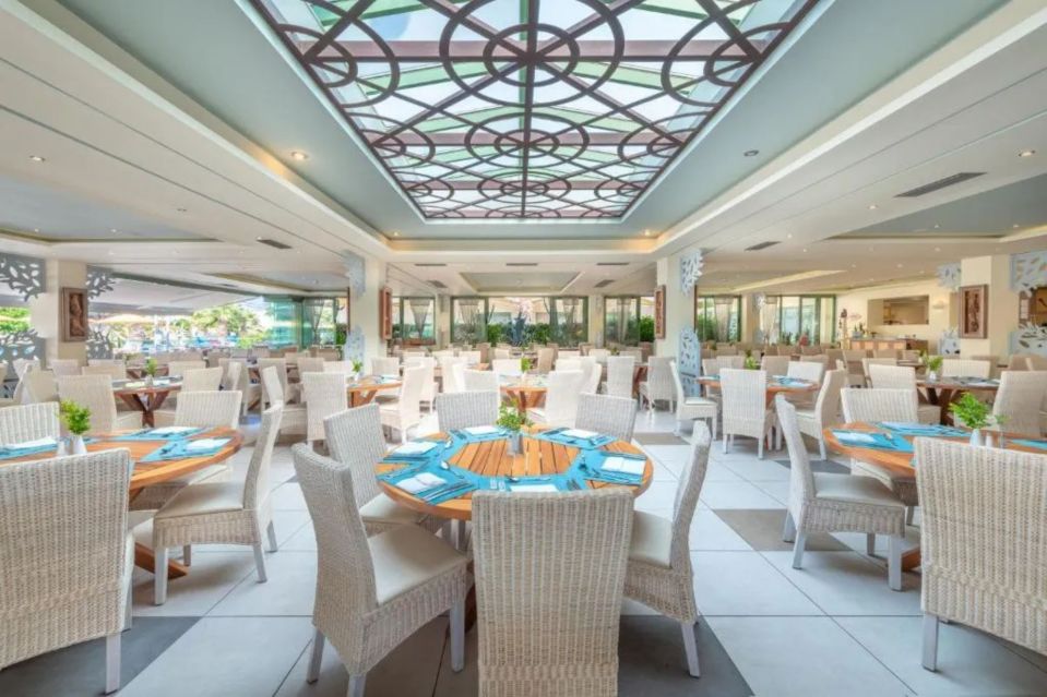 a restaurant with tables and chairs and a stained glass ceiling