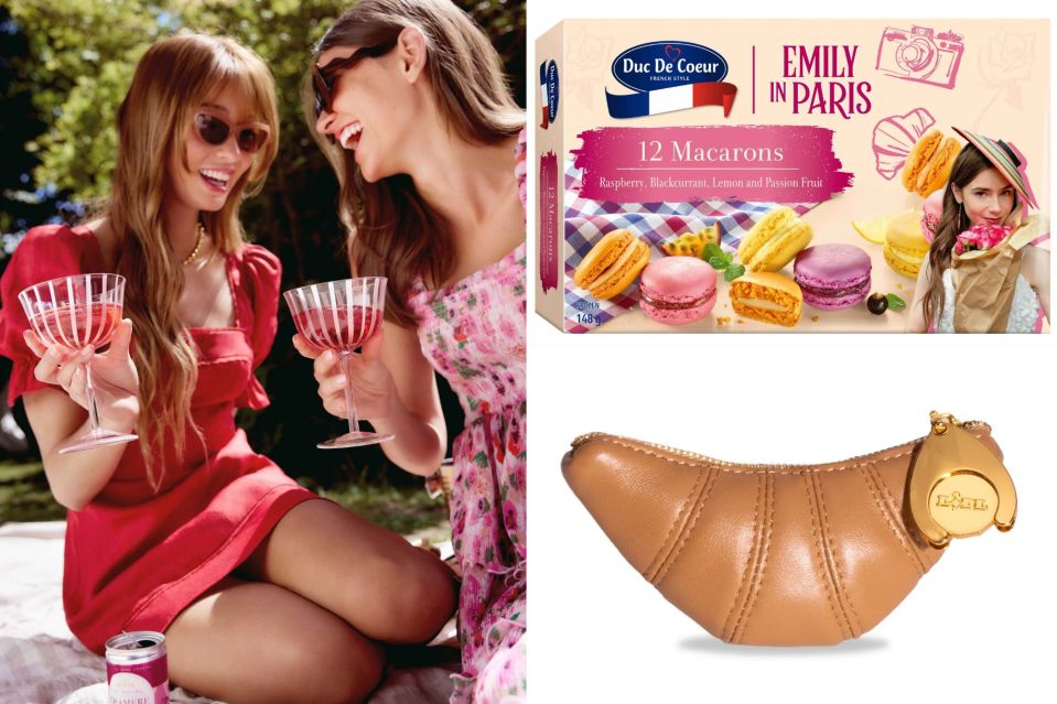 a box of emily in paris macarons sits next to two women holding wine glasses