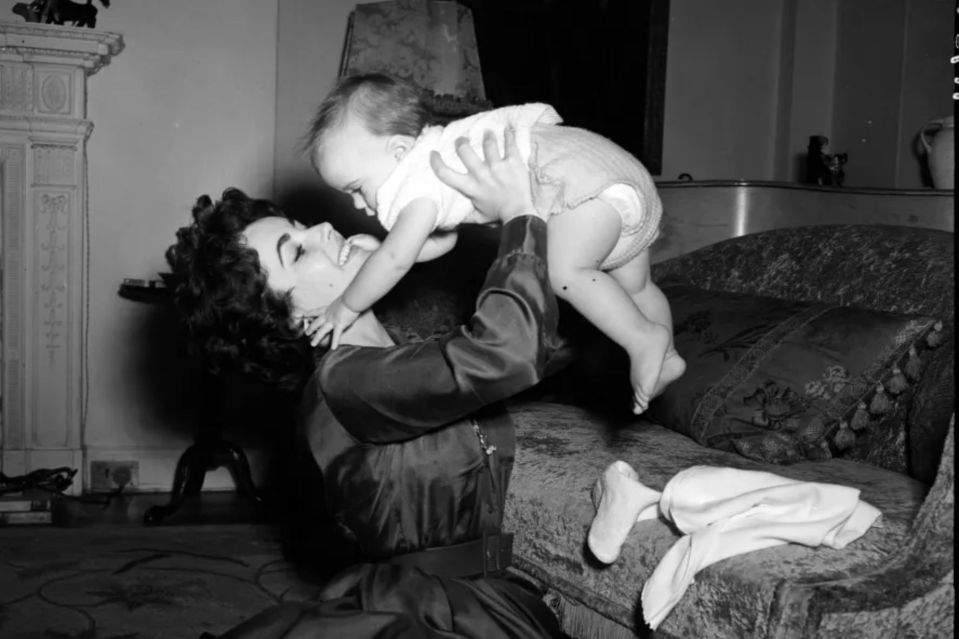 a black and white photo of a woman holding a baby