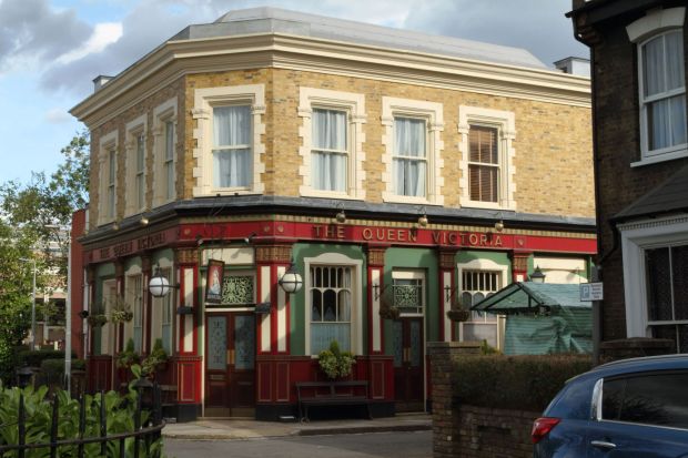 a building with a red sign that says the queen victoria