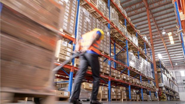 a man pushing a pallet in a warehouse with the number 07 on the shelves