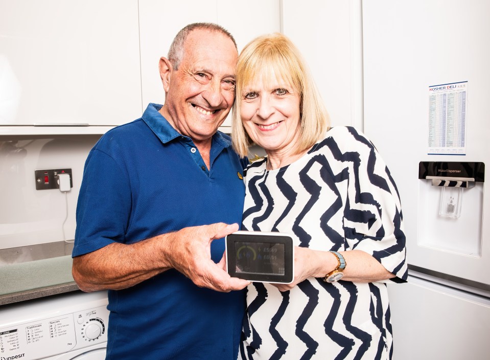 a man and woman standing in front of an indesit washing machine