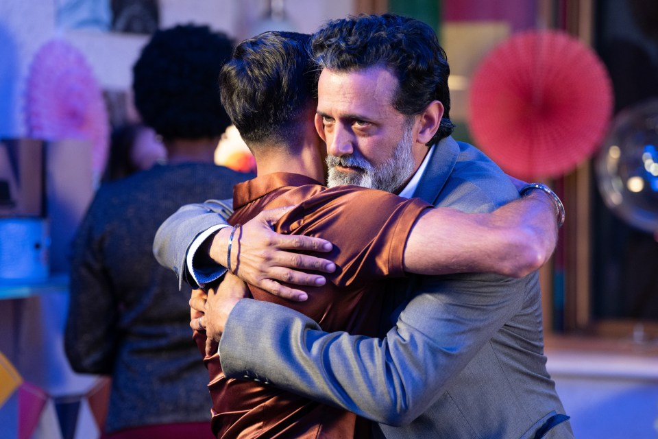 a man with a beard is hugging another man