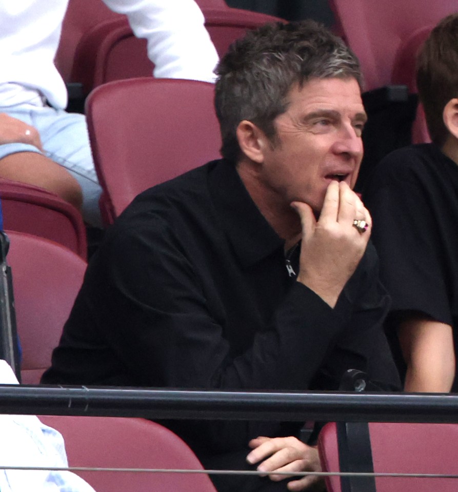 a man with a ring on his finger sits in a stadium