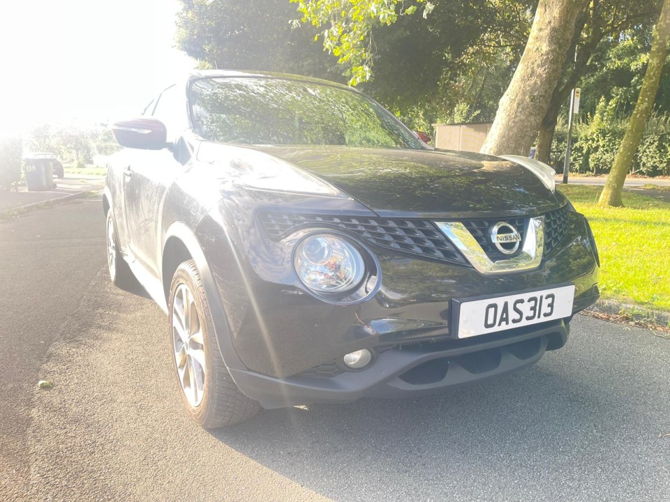 a black nissan car with a license plate that says oas313