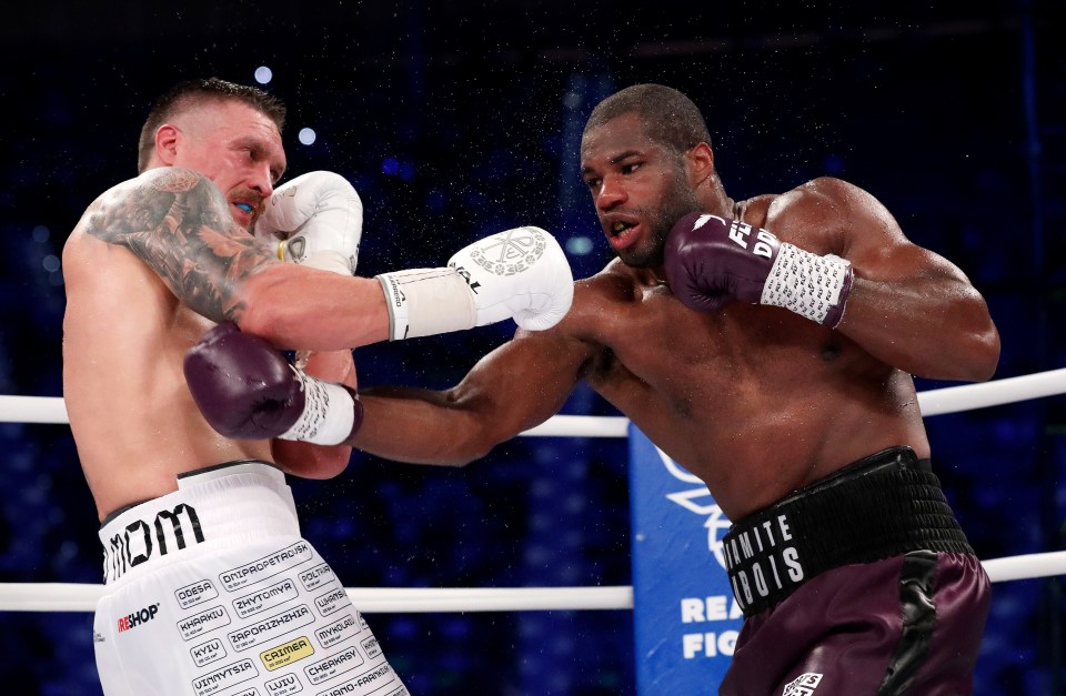 two boxers in a ring with one wearing a belt that says infinite trois