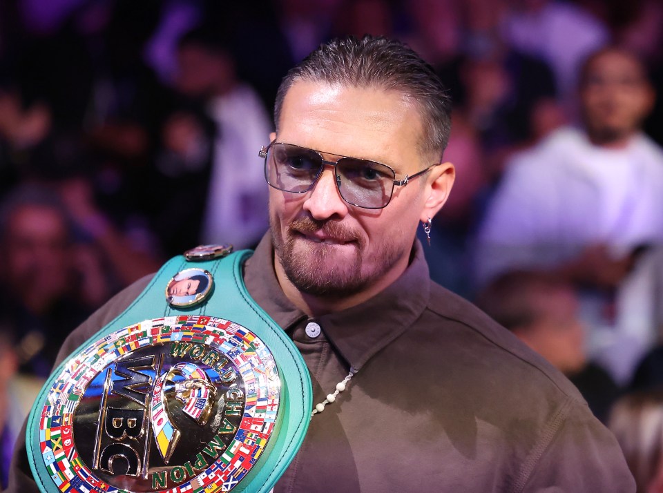 a man wearing glasses and a world heavyweight boxing belt