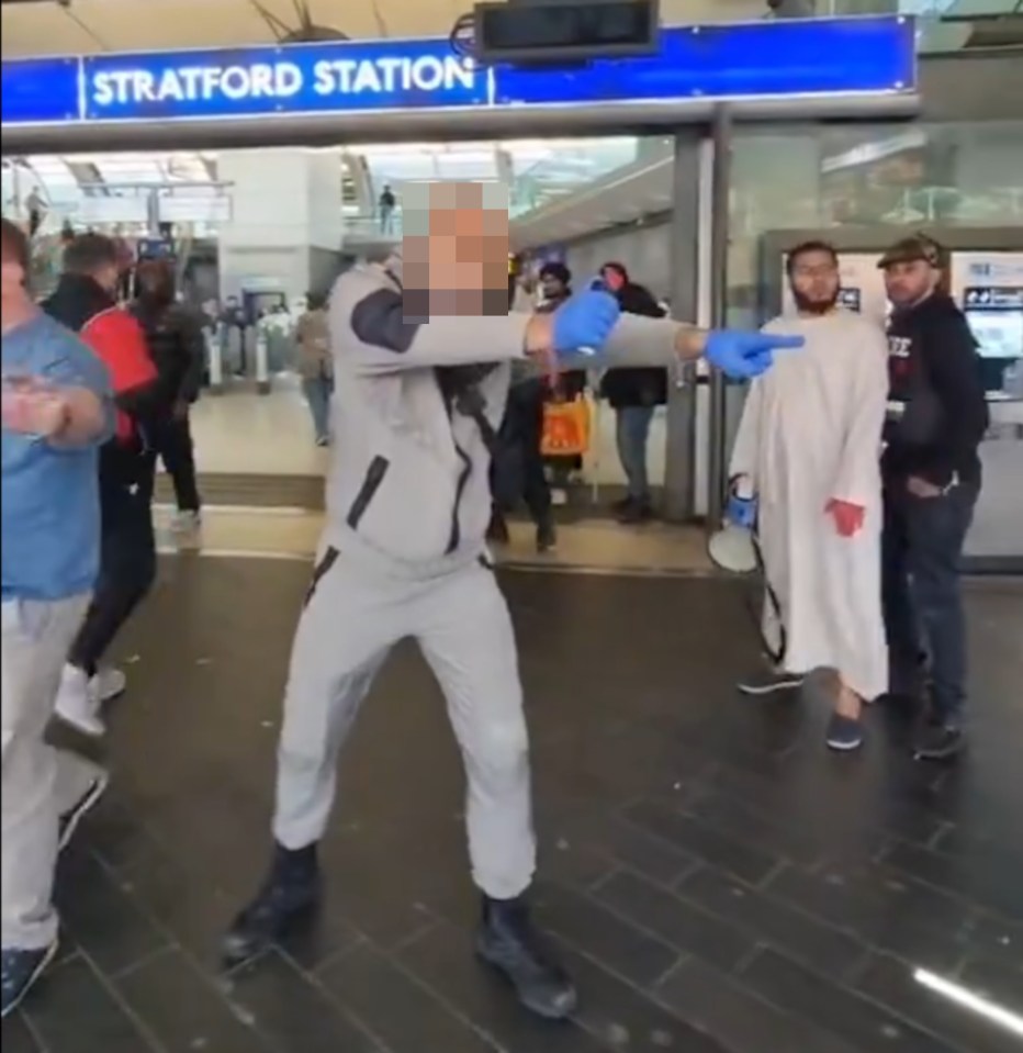 Standing with his arm outstretched, the man seems prepared to use the pepper spray and aims it directly at people nearby