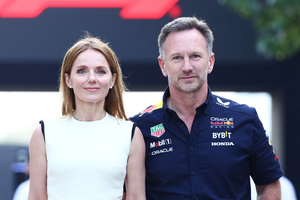 a man and a woman standing next to each other wearing red bull racing shirts