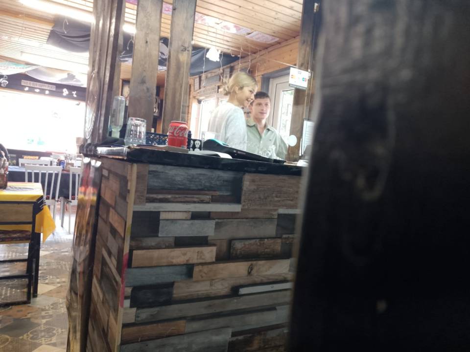 a man and a woman are behind a counter in a restaurant