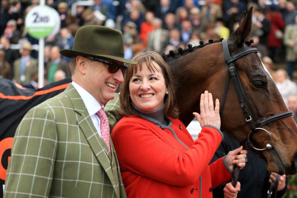 a man and woman standing next to a horse with a sign in the background that says 2nd