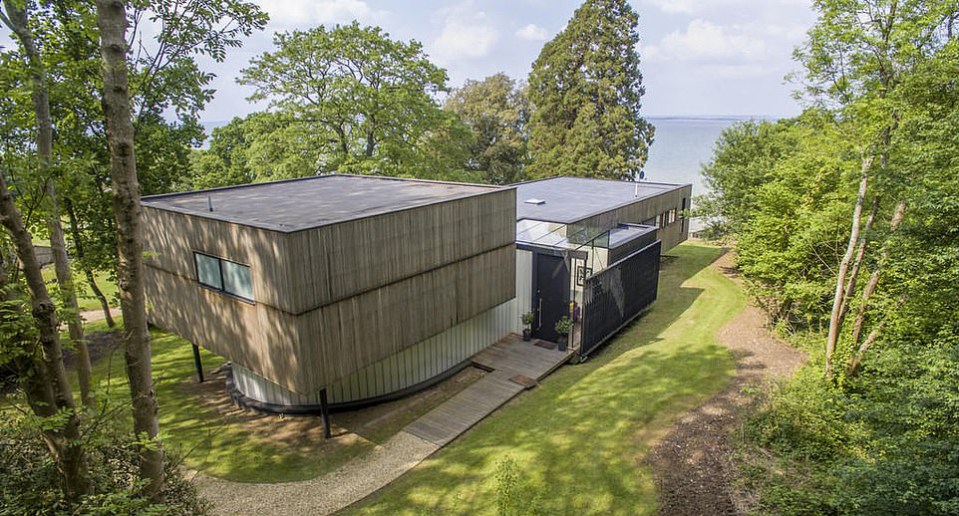 an aerial view of a modern house surrounded by trees