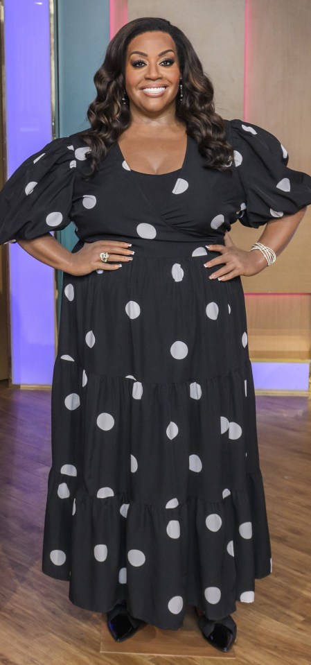 a woman wearing a black and white polka dot dress