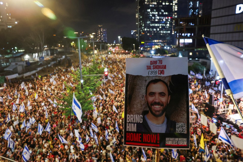 a large crowd of people holding flags and a poster that says bring him home now