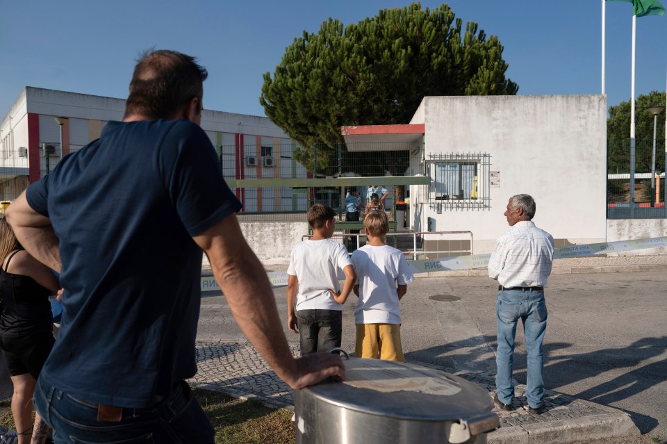 a group of people standing in front of a building that has a no parking sign on it