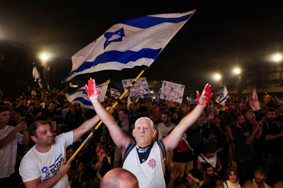 Israelis protested against the government for its handling of the hostage crisis - pictured: A person wears a mask of Israeli Prime Minister Benjamin Netanyahu with bloodied hands in Tel Aviv