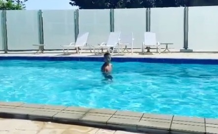 a man is jumping into a swimming pool .