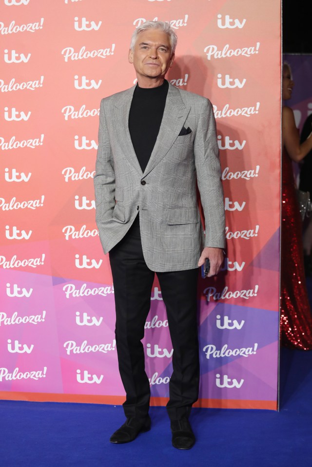 a man in a suit stands in front of a wall that says itv palooza