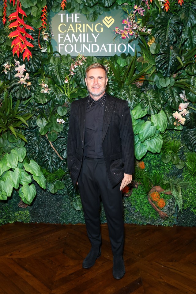 a man stands in front of a wall that says the caring family foundation