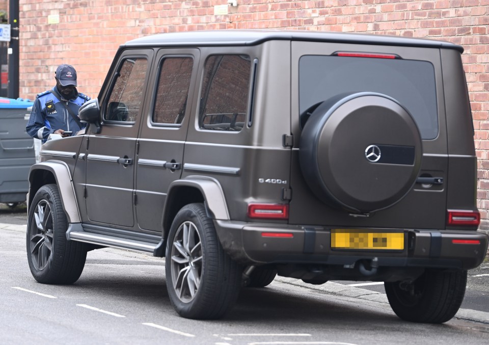 a mercedes g500 is parked in front of a brick building