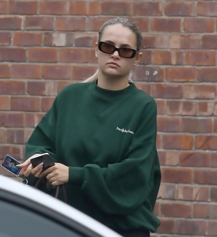 a woman wearing a green sweatshirt that says peace and love