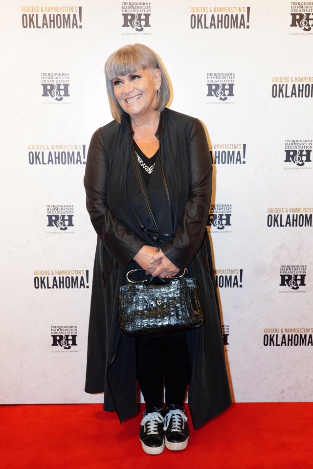 a woman stands on a red carpet with oklahoma written on it