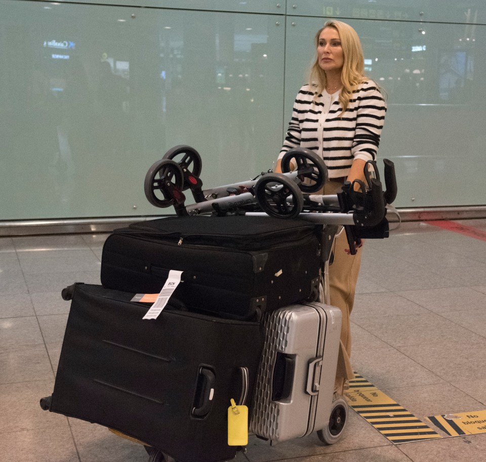 a woman pushes a cart full of luggage and a stroller