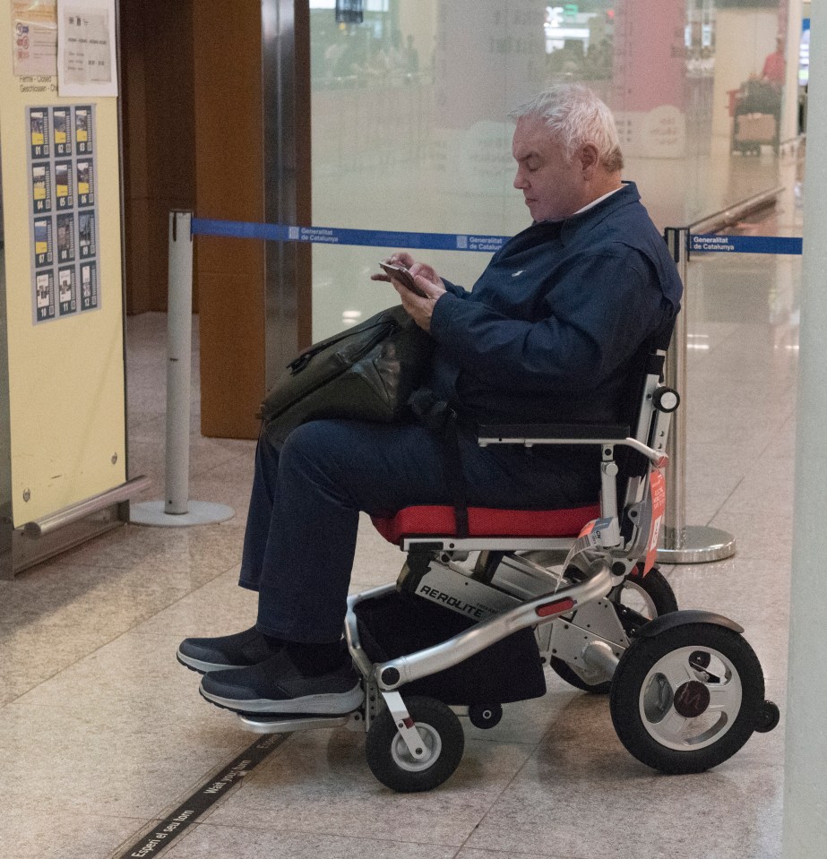 a man in a wheelchair is looking at his phone