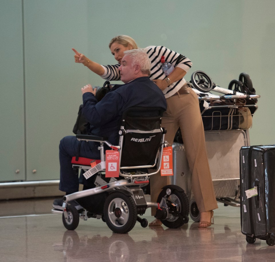 a man in a wheelchair is being pushed by a woman