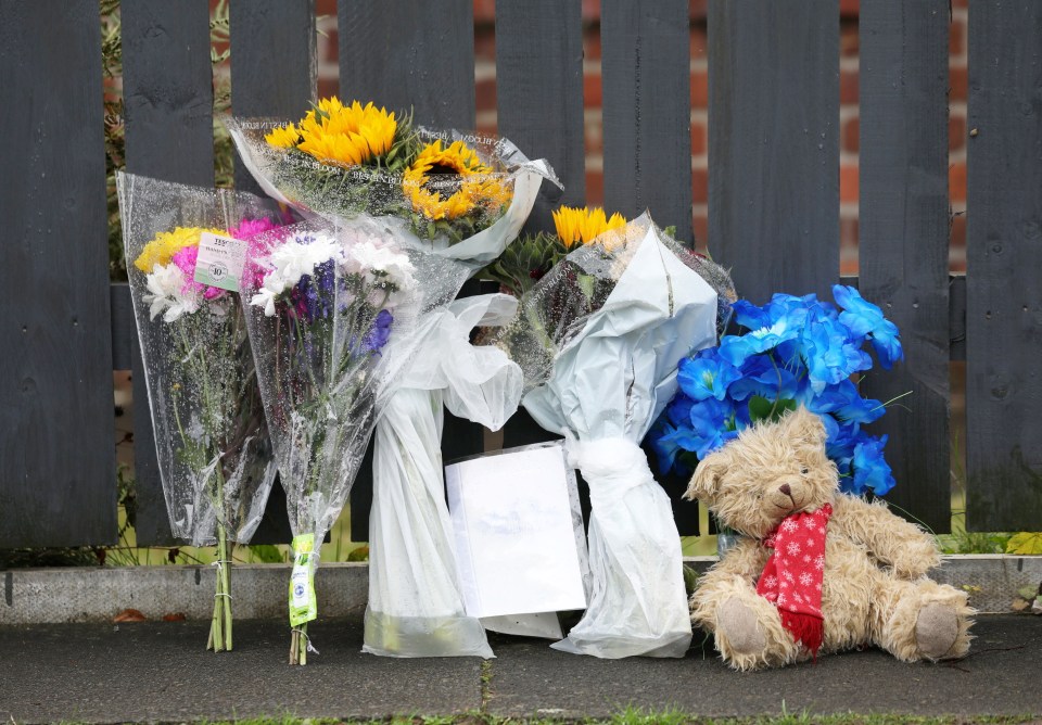 Flowers and a teddy have been left inside the police cordon