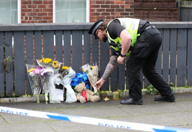 a police officer is putting flowers on a teddy bear