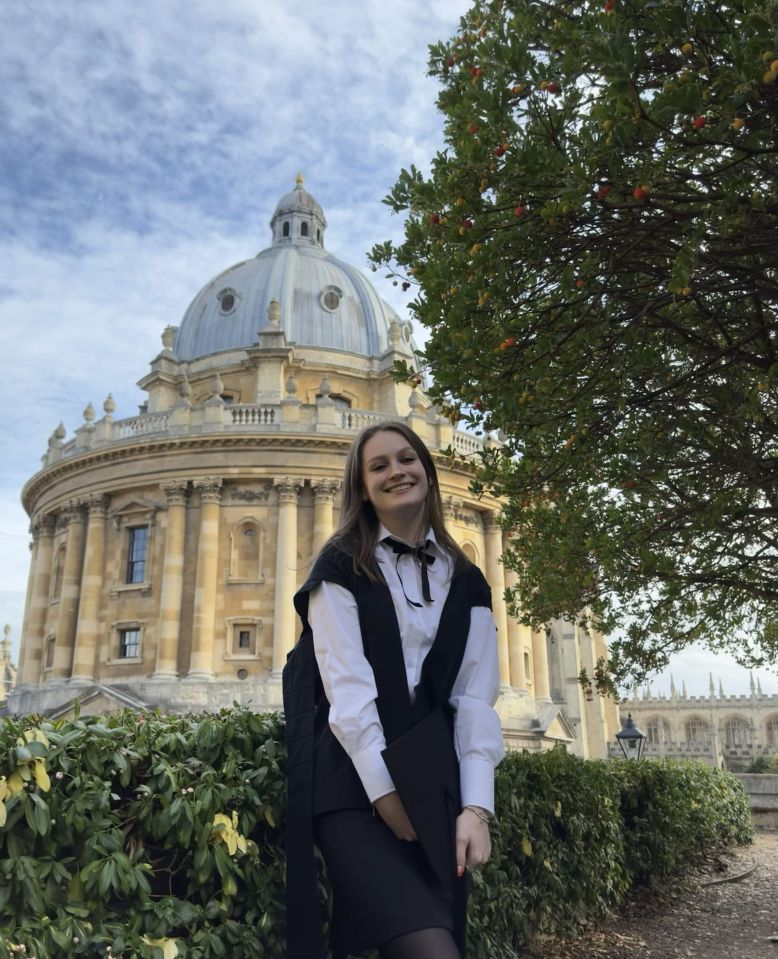 a woman stands in front of a building with a dome