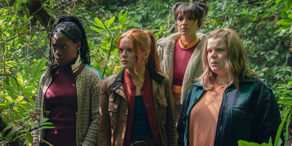 a group of women standing in the woods looking at something