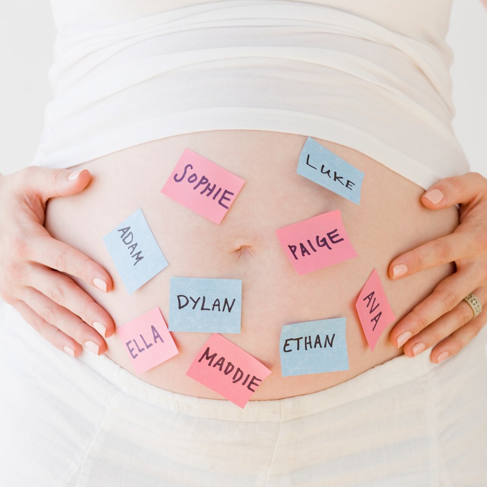 a pregnant woman holds her belly with sticky notes on it