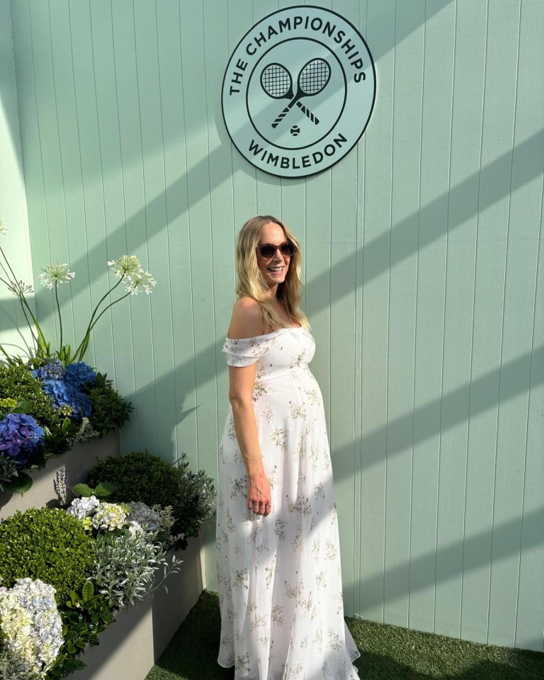 a pregnant woman stands in front of a sign that says the championships wimbledon