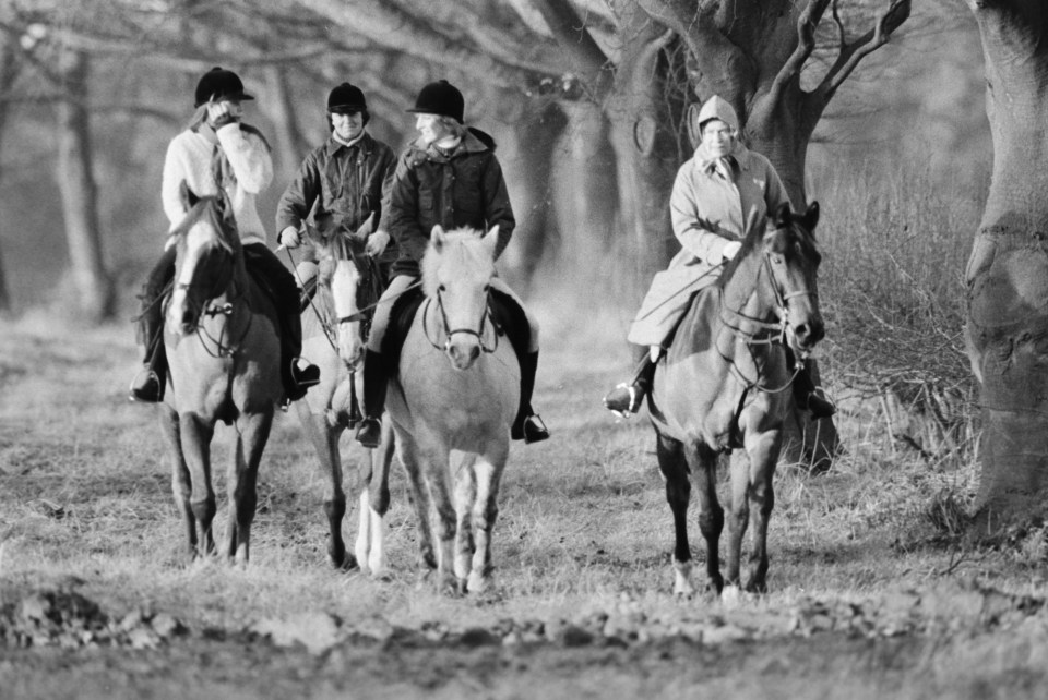 a black and white photo of people riding horses