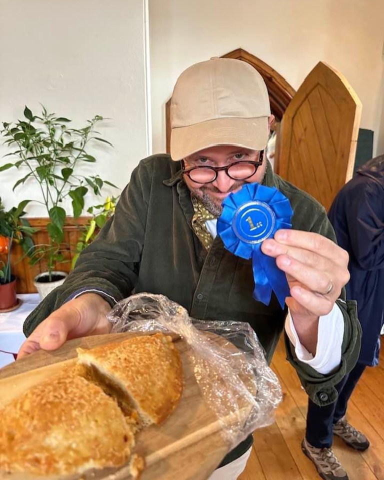 a man holding a blue ribbon with the number 1 on it