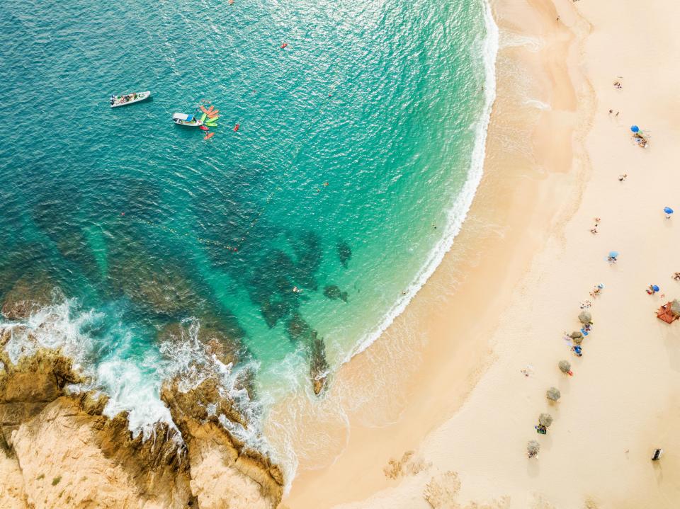 an aerial view of a beach with boats in the water