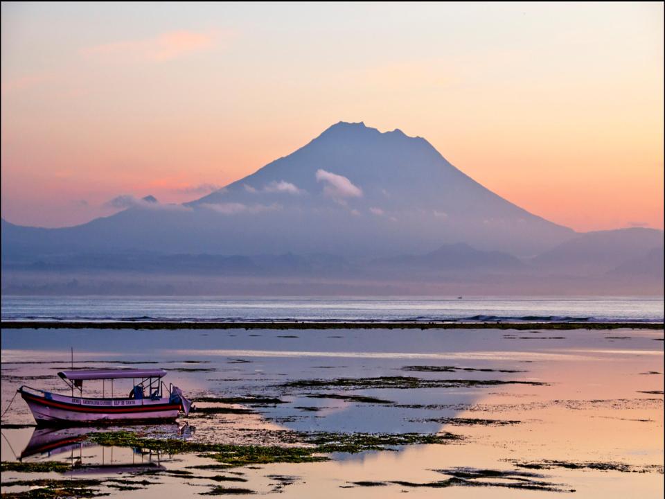 a boat in the water with a mountain in the background