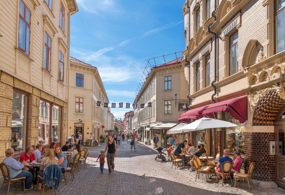 a group of people are walking down a cobblestone street