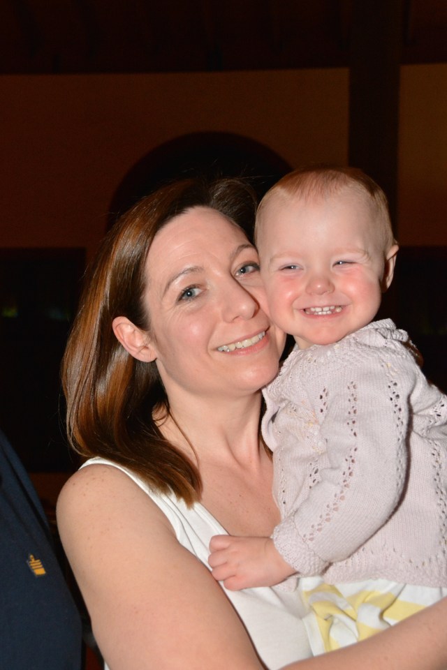 a woman is holding a baby and smiling for the camera