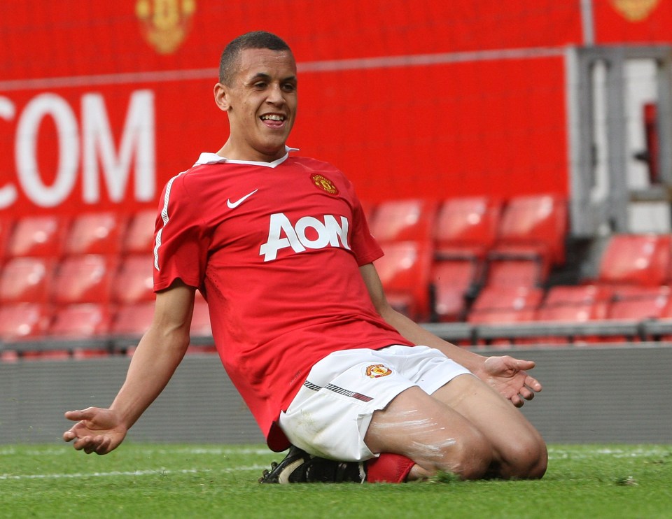 a man wearing a red aon jersey is kneeling on the field