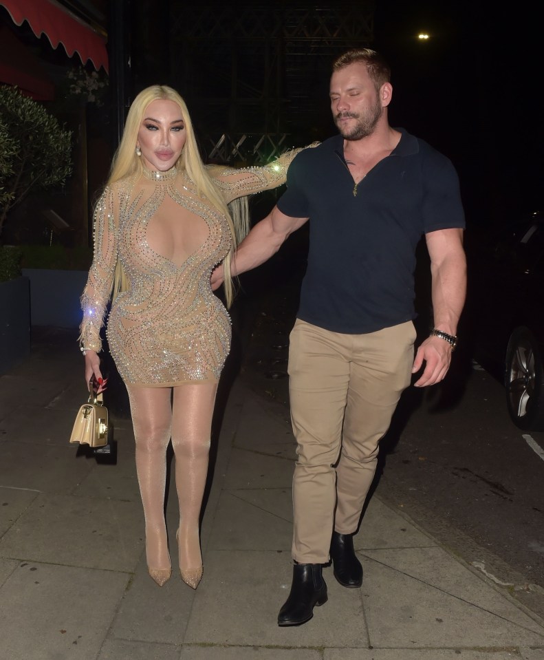 a man and a woman are walking down a sidewalk at night