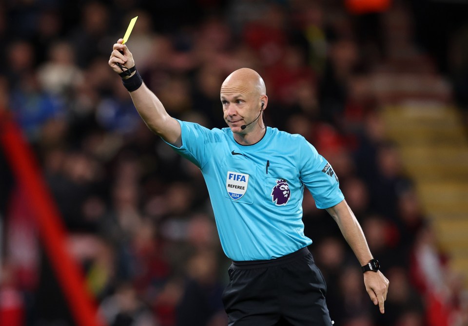 a referee holds up a yellow card that says fifa on it