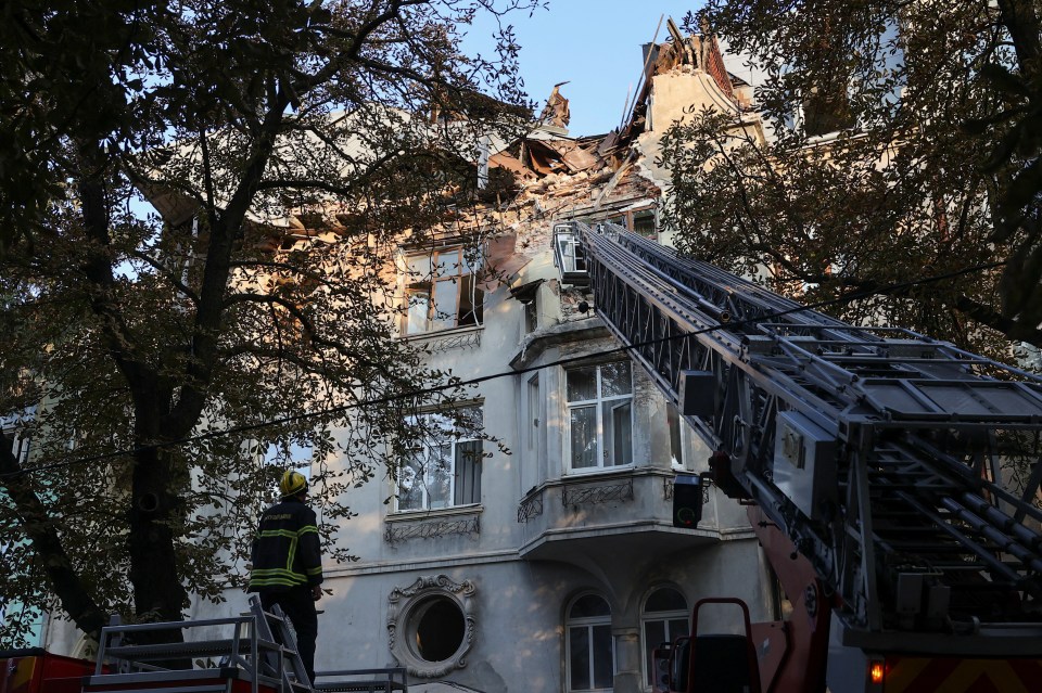 Rescuers work at the site of a residential building damaged during the Russian drone and missile attack