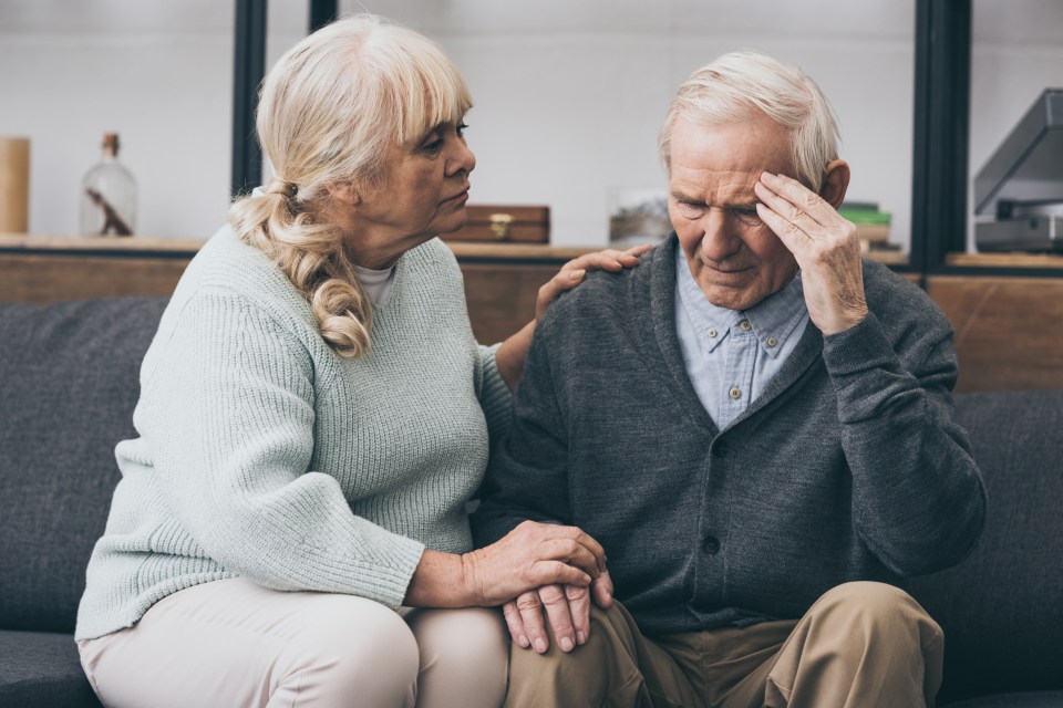 an elderly man with a headache is being comforted by his wife