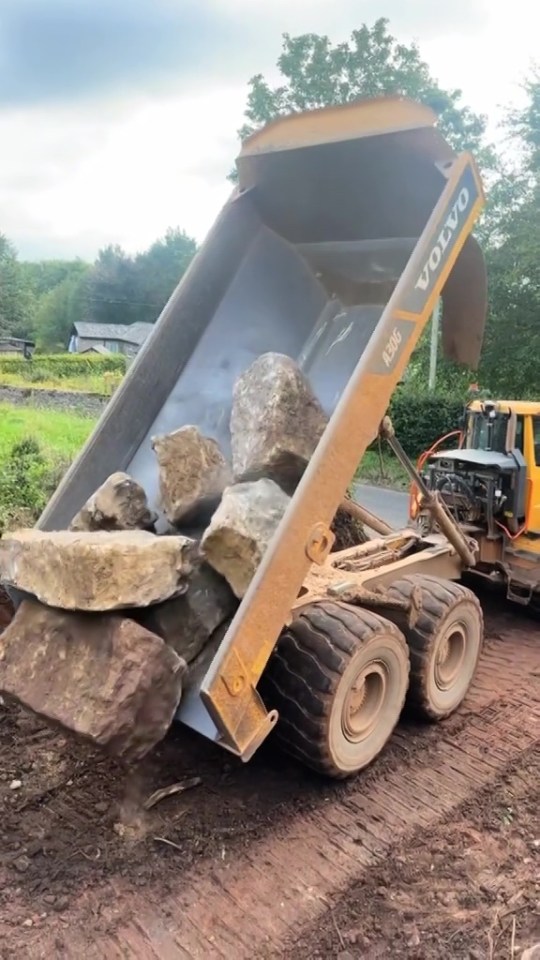 a volvo dump truck is loaded with rocks and dirt